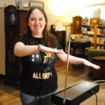 Amy Mulligan, a Doctor Who enthusiast and Spark Museum volunteer, demonstrates the theremin while wearing a Doctor Who t-shirt, highlighting the early electronic music technology that influenced the Doctor Who theme song.