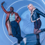 Ncuti Gatwa as the Doctor and Millie Gibson as Ruby Sunday in Doctor Who leaning against a silver wall